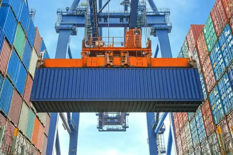 Shipping container being loaded by crane