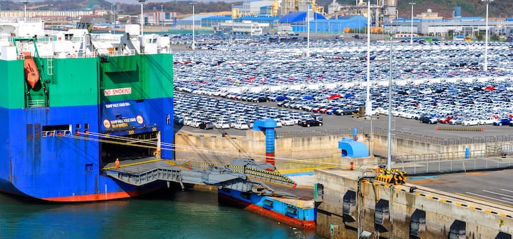 RORO vessel docked at port with vehicles awaiting shipping